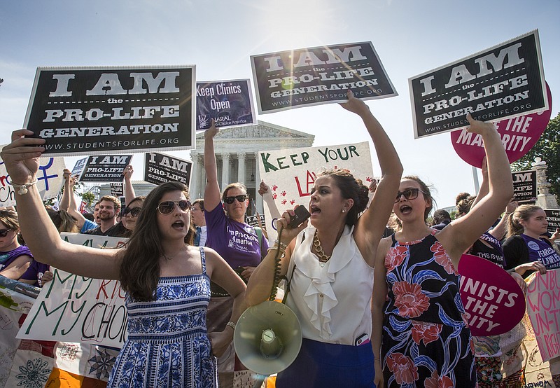 Reagan Barklage of St. Louis, center, and other anti-abortion activists demonstrate in front of the Supreme Court in Washington, Monday, as the justices released a decision that does not make the health of women primary.