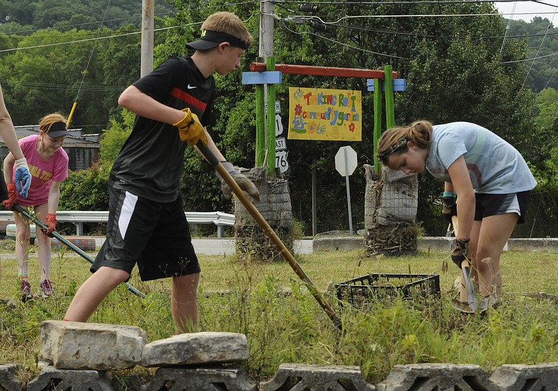 Josh Miller, center, Julia Herrera, right, and Hope Holloway, back left, work to beautify the Taking Root Community Garden Tuesday in conjunction with Son Servants in Ridgedale. The middle school students represent Signal Mountain Presbyterian and Roswell (Ga). Presbyterian volunteers. The garden is locate at S. Main and Watkins streets.