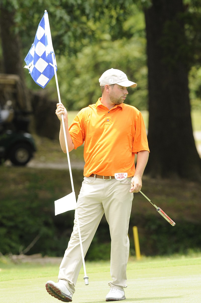 Casey Flenniken pulls the flag at No. 17, on his way to a 6-under-par tournament win at Creeks Bend Golf Club in Hixson on Tuesday. 