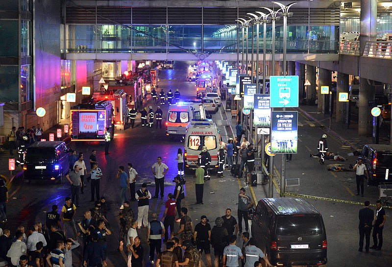 
              Medics and security members work at the entrance of the Ataturk Airport after explosions in Istanbul, Tuesday, June 28, 2016. Two explosions have rocked Istanbul's Ataturk airport, killing several people and wounding others, Turkey's justice minister and another official said Tuesday. A Turkish official says two attackers have blown themselves up at the airport after police fire at them. The official said the attackers detonated the explosives at the entrance of the international terminal before entering the x-ray security check. (IHA via AP) TURKEY OUT
            