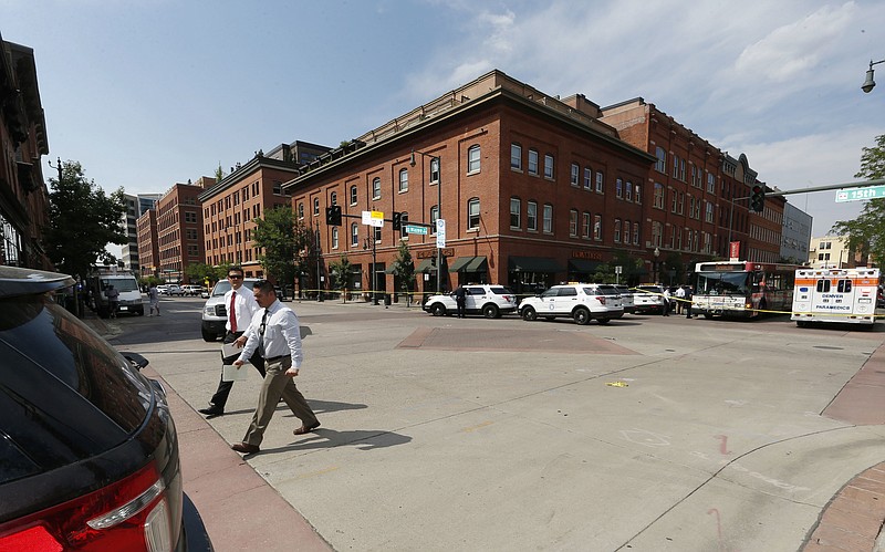 
              Investigators walk through the intersection of 15th Street and Wazee near the scene of a shooting in a lower downtown business Tuesday, June 28, 2016, in Denver. Officers responded to the business after a report of a gunman, blocking several streets in the congested area. (AP Photo/David Zalubowski)
            