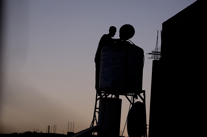 
              In this Saturday, June 18, 2016 photo, a Palestinian man checks the water tank on the roof of his home after water supply was cut in the village of Salem near the West Bank city of Nablus. Palestinians in the West Bank have long faced shortages of water in the summer months. But this year, as they fast dawn-to-dusk amid scorching heat during the Muslim holy month of Ramadan, many villagers in the north of the territory say Israel has intentionally cut the water flow to their taps. (AP Photo/ Majdi Mohammed)
            