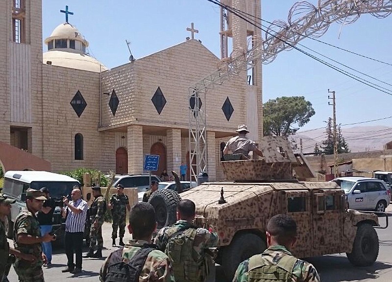 
              Lebanese army patrol in front a church in Qaa, a predominantly Lebanese Christian village only few hundred meters (yards) away from the Syrian border, eastern Lebanon, Monday, June 27, 2016. A group of suicide bombers detonated their explosives in the Lebanese village near the border with Syria on Monday, killing and wounded several people, Lebanon's state-run news agency said. (AP Photo)
            