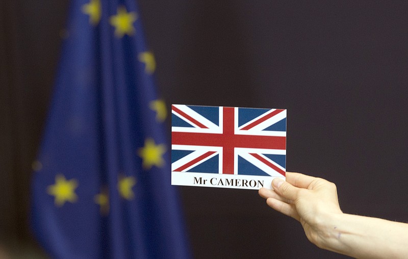
              A member of the press service holds up a placement card for British Prime Minister David Cameron at the end of a group photo at an EU summit in Brussels on Tuesday, June 28, 2016. EU heads of state and government meet Tuesday and Wednesday in Brussels for the first time since Britain voted to leave the European Union, throwing British and European politics into disarray. (AP Photo/Geoffroy Van der Hasselt)
            