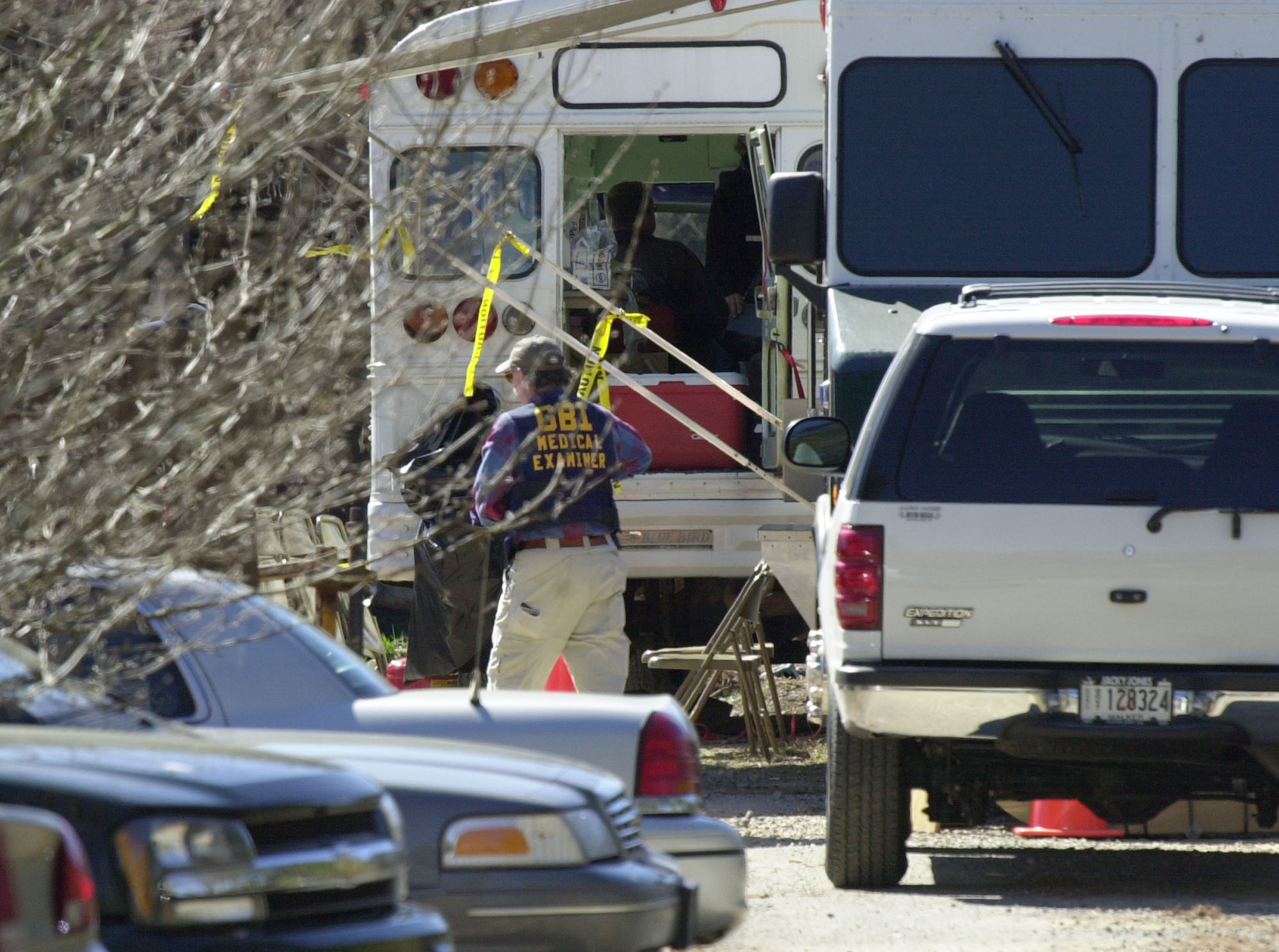 A Georgia Bureau of Investigation medical examiner walks by the command center at the Tri-State Crematory on the property of Ray Brent Marsh, 28, outside of Noble, Ga., Sunday, Feb. 17, 2002. Marsh allegedly took in the bodies of deceased people for cremation and then stored them on the property. Authorities have sealed off the track while they work to recover the bodies. (AP Photo/Ric Feld)