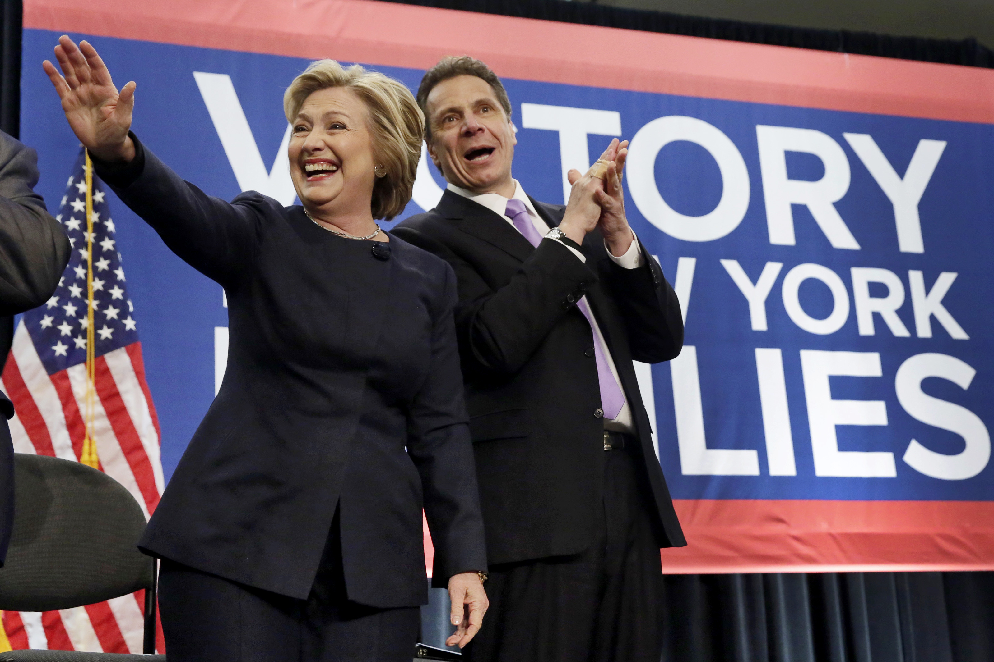 Democratic presidential candidate Hillary Clinton and New York Gov. Andrew Cuomo acknowledge the crowd as they are introduced at the Javits Convention Center in New York, Monday, April 4, 2016. Cuomo has signed a law that will gradually raise New York's minimum wage to $15. Cuomo and Clinton marked the occasion at a Manhattan rally with labor leaders and workers. (AP Photo/Richard Drew)