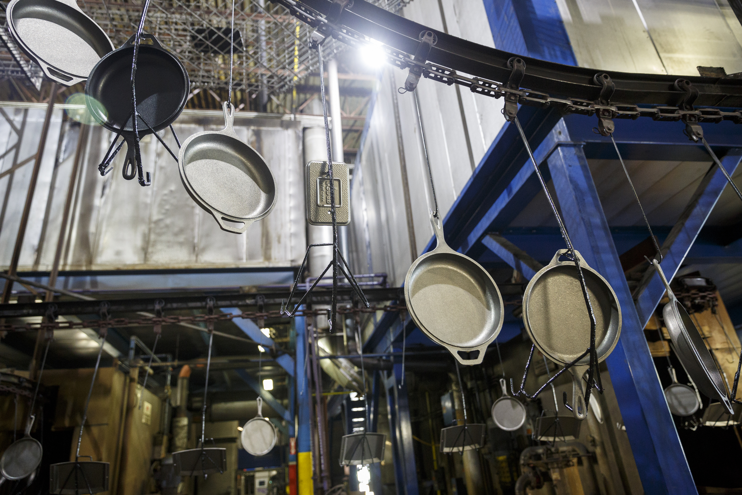 Cast iron cookware is moved by conveyor to be seasoned at Lodge Manufacturing on Wednesday, June 29, 2016, in South Pittsburg, Tenn. The cast iron cookware manufacturer broke ground Wednesday on a new foundry.