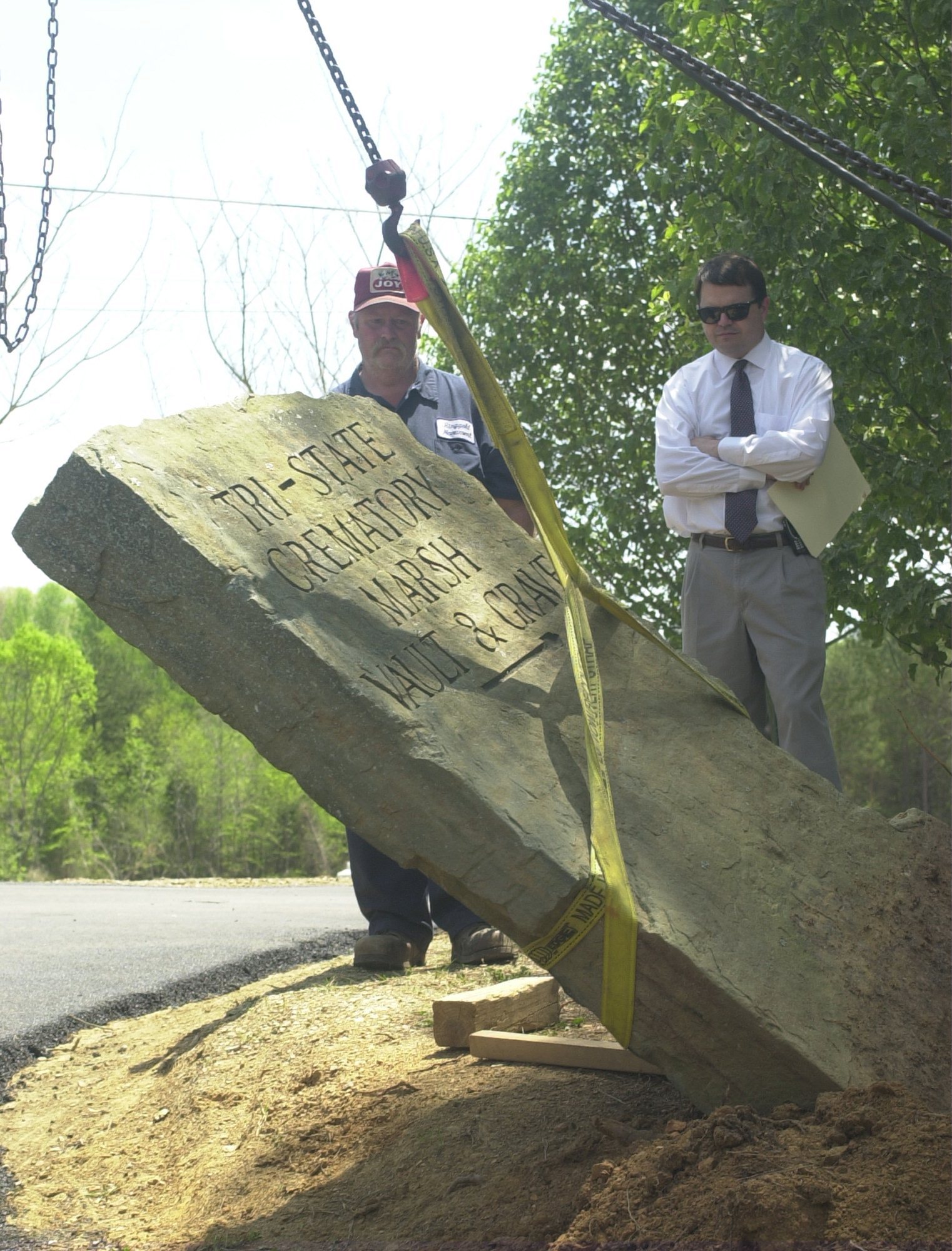 The Tri-State Crematory sign in front of the Marsh property on Center Point Road was removed Friday while Marsh family attorney McCracken "Ken" Poston watches on with Steve Reece, Ringgold Monument employee. The property was turned back over to the Marshes by officials with the Tri-State Crematory investigation.( Photo by Juliette Coughlin/ Chattanooga Times Free Press/ 4/19/02)