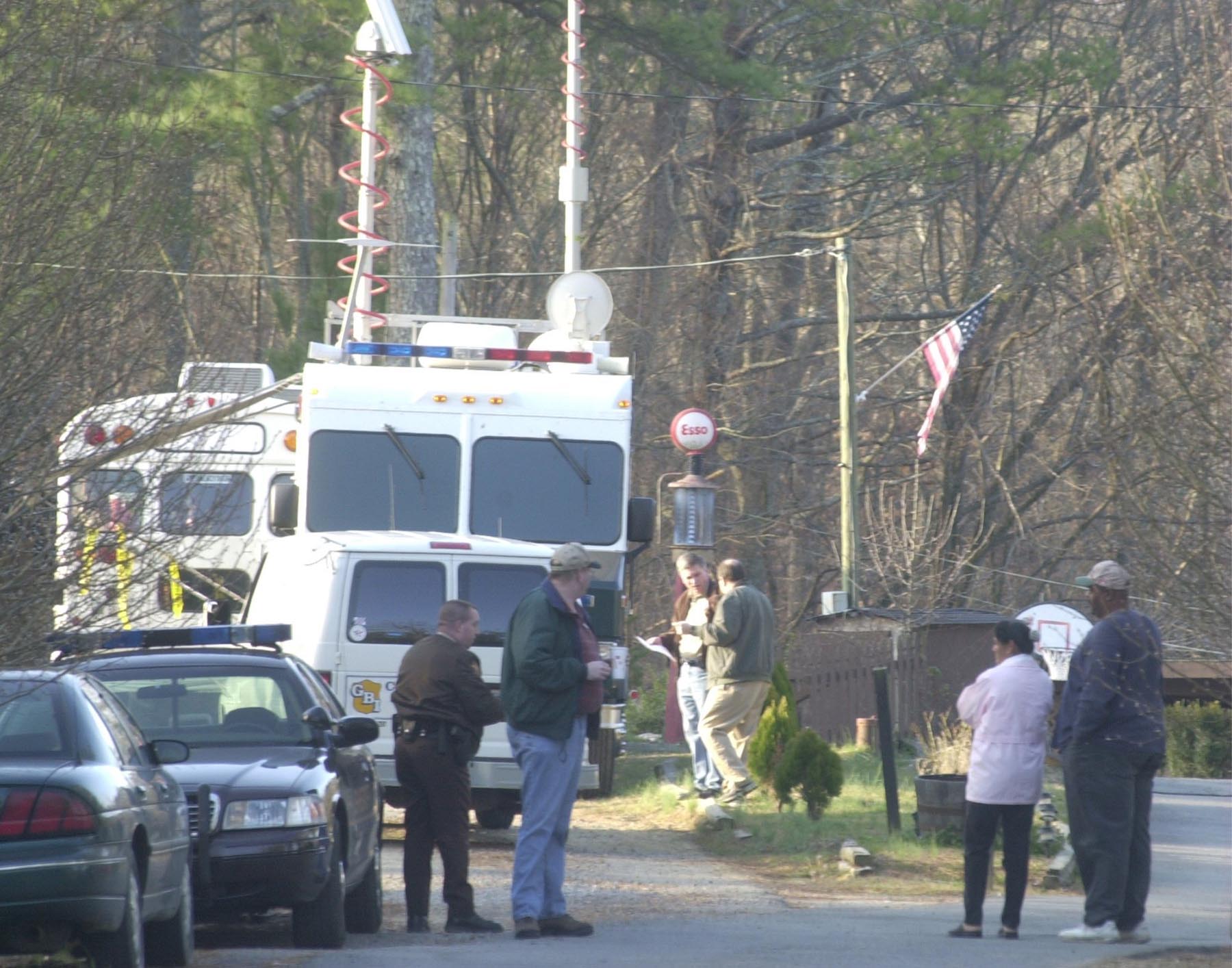 Christine Dallas and her brother-in-law Michael Dallas talk to law enforcement officials in the driveway  of the Tri-State Crematory Saturday morning. Christine's husband was supposed to be cremated at the facility and they are hoping to find out whether or not his body is among te 49 already found at the site.