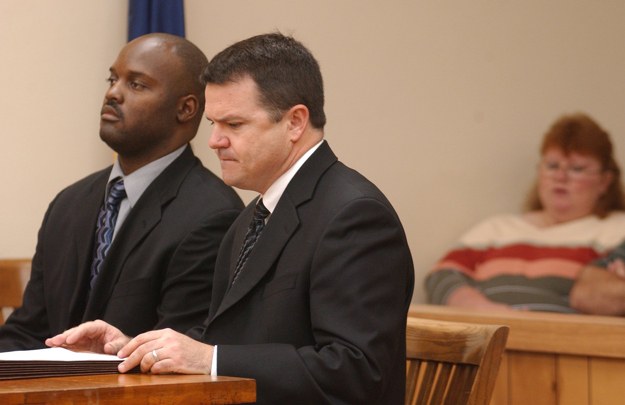 Former crematory operator Ray Brent Marsh, left, appeares in court for arraignment Tuesday, Sept. 23, 2003, in LaFayette, Ga., with his attorney Ken Poston. Lisa Cash, far right, watches the proceedings from the gallery. Marsh pleaded not guilty to 122 counts of burial service fraud and 47 counts of making false statements. Marsh, accused of dumping decaying bodies around his family business, faces multiple counts of burial service fraud, making false statements, abuse of a dead body and theft. He remains free on bond. (AP Photo/Chattanooga Times Free Press, Kathleen Cole)