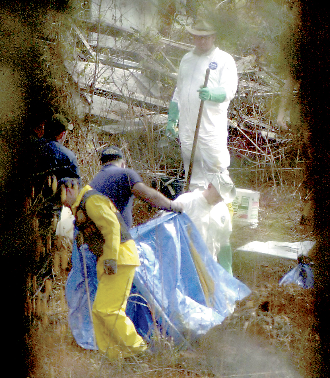 GBI workers collect human remains from the property of Brent Marsh who lives near the Tri State Crematory Wednesday Feb. 20, 2002 in Noble, Ga.