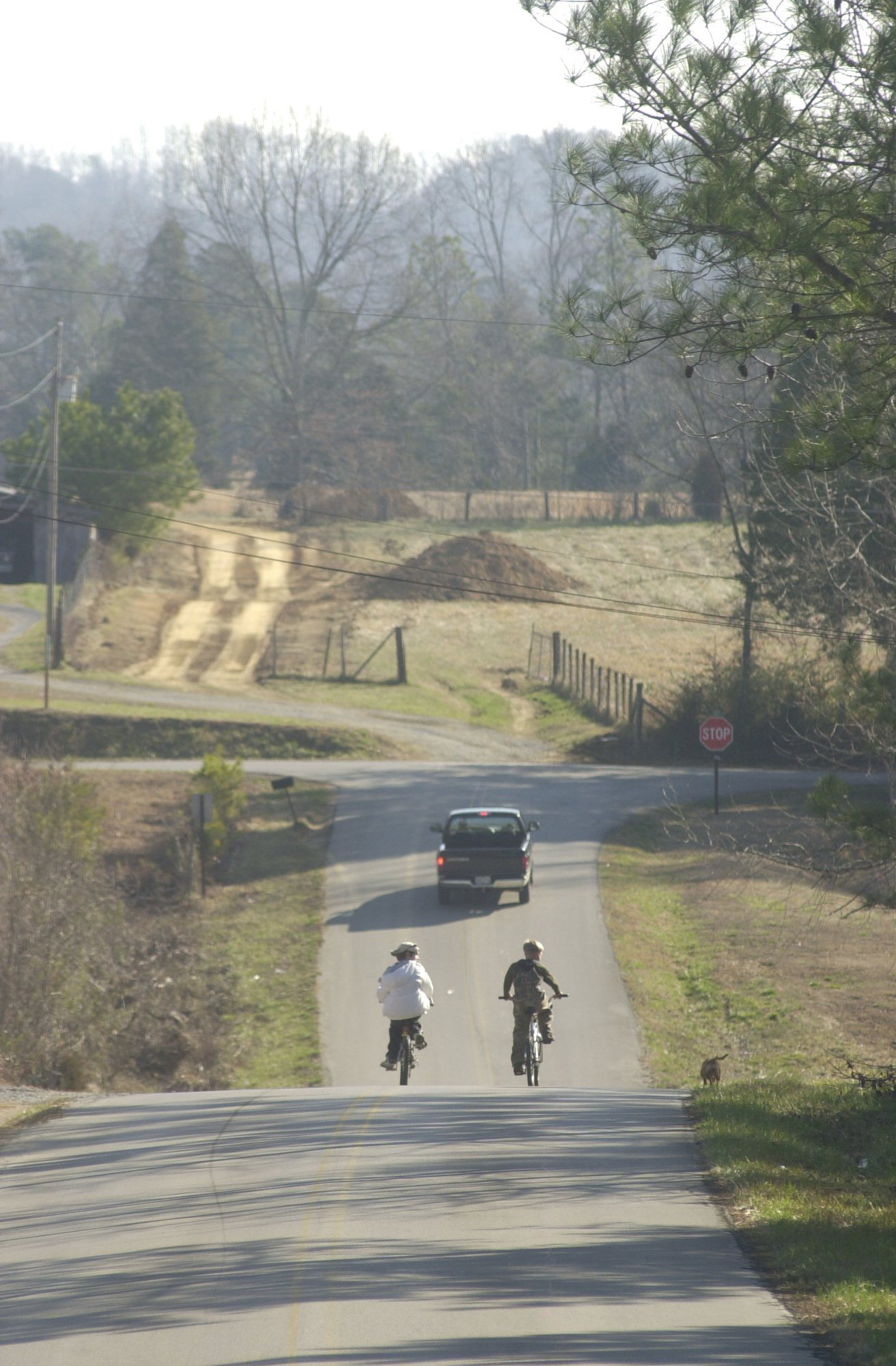 Neighborhood children ride their bikes on Center Point Road in Noble Georgia, less than 100 yards from where more than 300 bodies were discovered on the property of Tri-State Crematory. The Marsh family property borders the road on the right side of this picture.