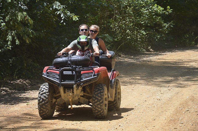 Chris Williams and his wife, Makayla, and their 3-year old son, Braylon, ride their ATV on an off-highway vehicle road in the Houston Valley OHV trail. The popular trail system is located in the Chattahoochee-Oconee National Forest.