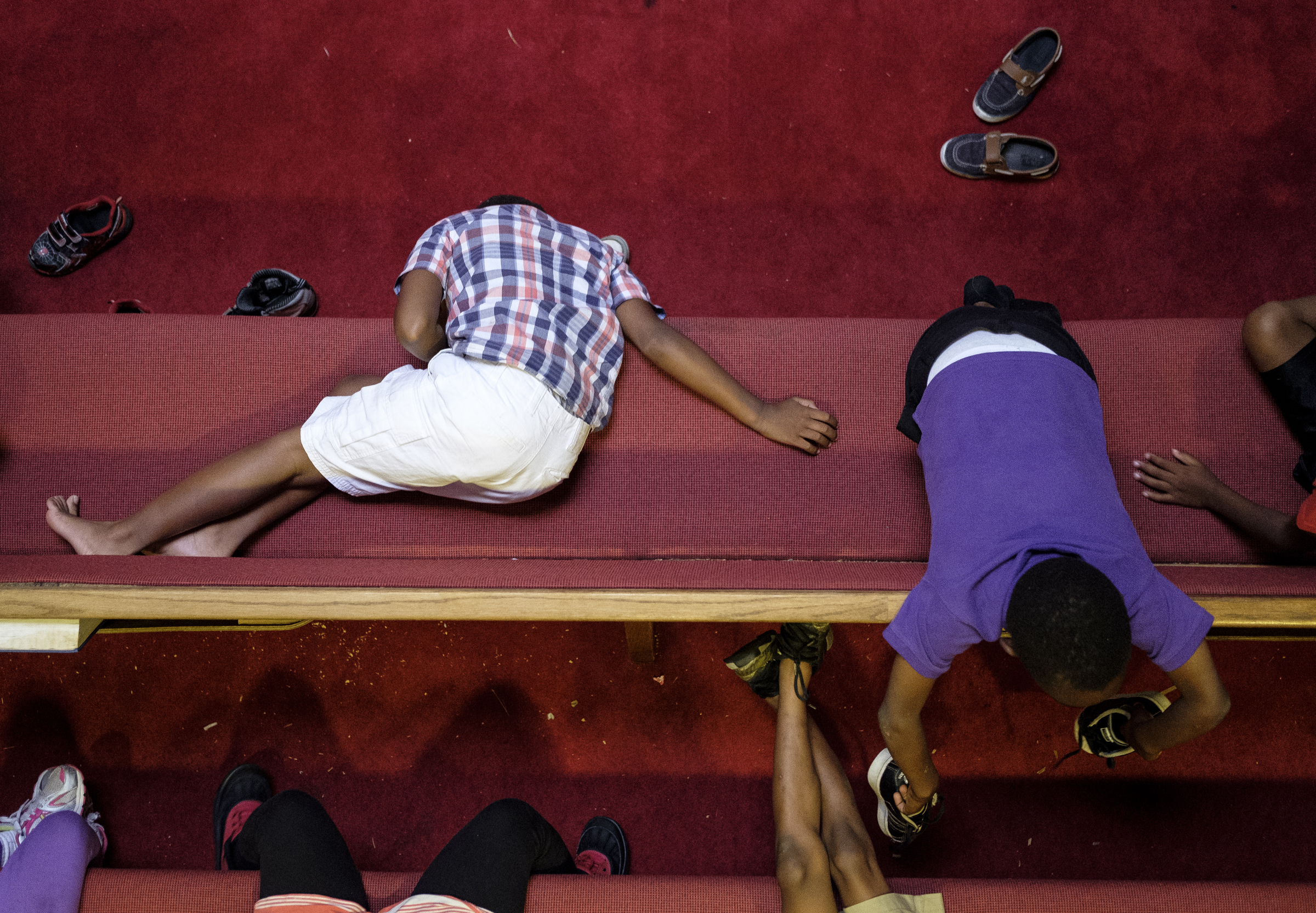 Kids sit in church pews as a video lesson plays on a screen at a camp for kids operated by Gloria Griffith at Renaissance Presbyterian Church on Tuesday, June 28, 2016, in Chattanooga, Tenn. Griffith has operated the camp for 5 years, but because of health problems, Griffith expects that she will have to end the camp this month if she can't find someone to take her place.
