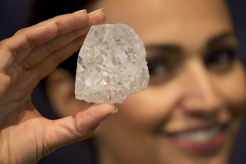 
              FILE - In this Tuesday, June 14, 2016 file photo, a model poses for photographs holding up the largest gem-quality rough cut diamond discovered in over 100 years, the 1109-Carat “Lesedi La Rona” at premises of the Sotheby's auction house in London. The tennis ball-sized Lesedi la Rona failed to find a buyer Tuesday June 29, 2016, a disappointing result for a stone which had described as “the find of a lifetime” by David Bennett, chairman of Sotheby's jewelry division. (AP Photo/Matt Dunham, File)
            