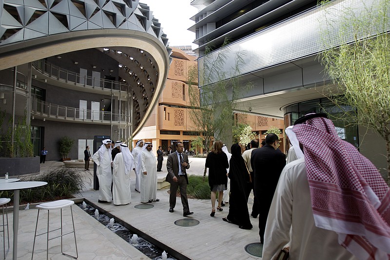 
              FILE - In this Sunday, Jan. 16, 2011 file photo, People visit the Masdar Institute campus, part of Masdar City, a Mubadala company, in Abu Dhabi, United Arab Emirates. A top official in the United Arab Emirates has issued an order for the merging of two of the Gulf nation's most prominent government wealth funds, streamlining the country's investment strategy as it weathers a slump in oil prices. (AP Photo/Kamran Jebreili, File)
            