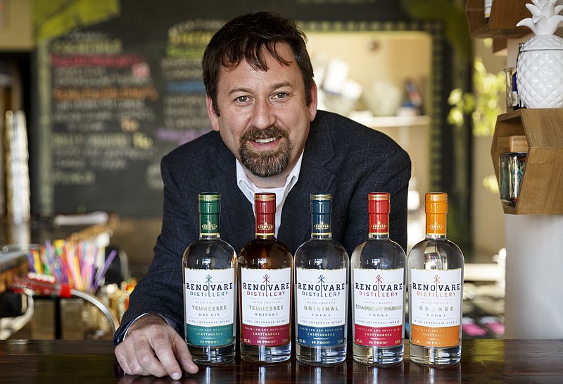 Renovare Distillery owner Keith McConnell poses for a portrait with prototype bottles for the distillery's spirits at The Bitter Alibi.