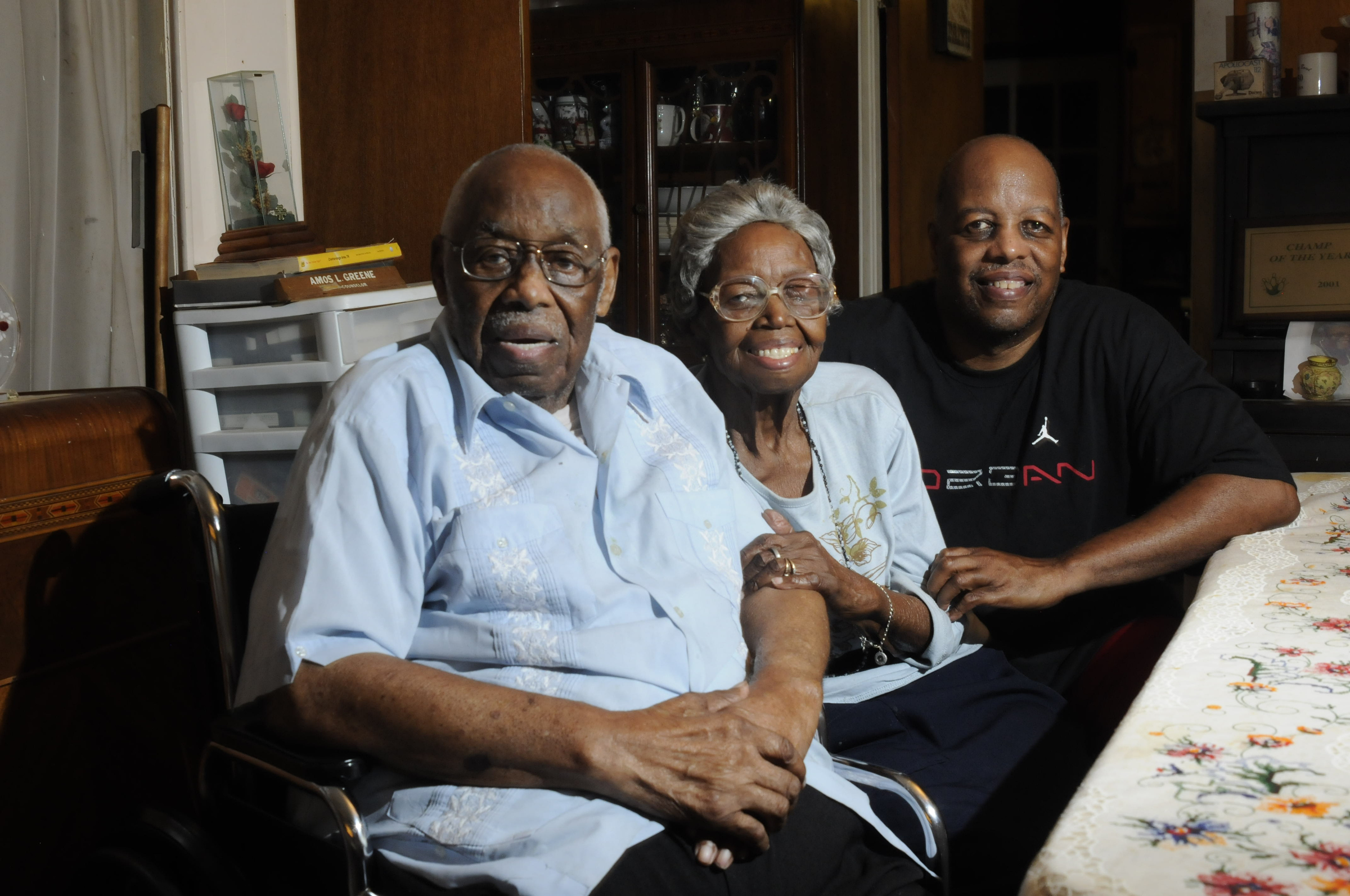 Amos Greene, 97, and Annie Greene, 94, talk about their lives together from their Riverside Drive dining room. The Greenes have been married for 70 years. Their son, Michael Greene, far right, sees to their needs.