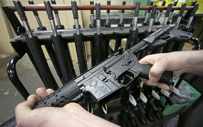 
              FILE - In this April 10, 2013, file photo, a man holds a newly-assembled AR-15 rifle in New Britain, Conn. A gun shop in McHenry, Ill., is raffling an AR-15 rifle to benefit victims of the June 12, 2016, nightclub shooting in Orlando, Fla. The semi-automatic weapon is similar to the one gunman Omar Mateen used in that shooting. (AP Photo/Charles Krupa, File)
            