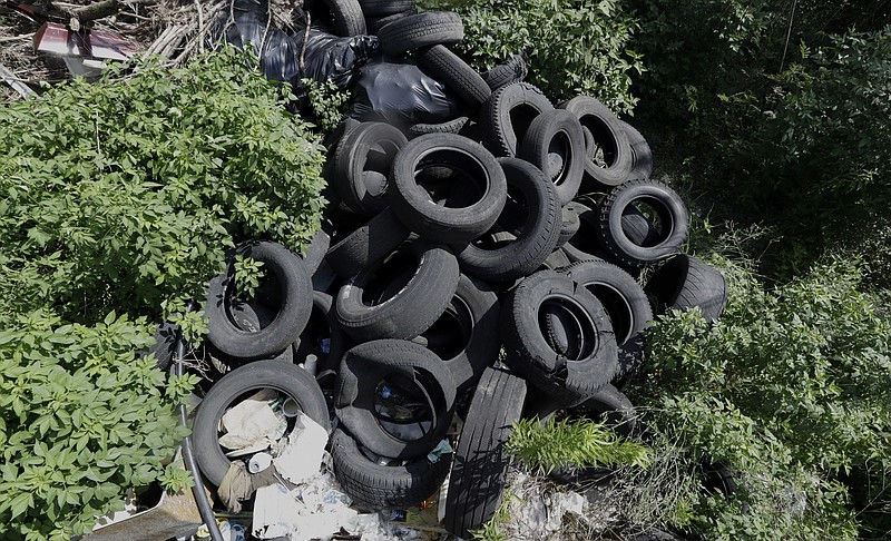 
              In this photo taken June 22, 2016, a pile of tires sits in a neighborhood near downtown Houston. Trash piles like this are textbook habitat for the mosquitoes that carry Zika, and one example of the challenge facing public health officials. (AP Photo/David J. Phillip)
            
