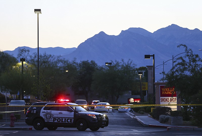 
              In this photo taken Wednesday, June 29, 2016, Las Vegas police investigate a homicide outside of a Walgreens at Lake Mead and Jones Boulevards in Las Vegas. A man chased and gunned down his wife outside the drug store and killed their three children at an apartment in Las Vegas before apparently shooting himself, leaving five members of a family dead, authorities said Thursday, June 30, 2016.  (Chase Stevens/Las Vegas Review-Journal via AP)
            