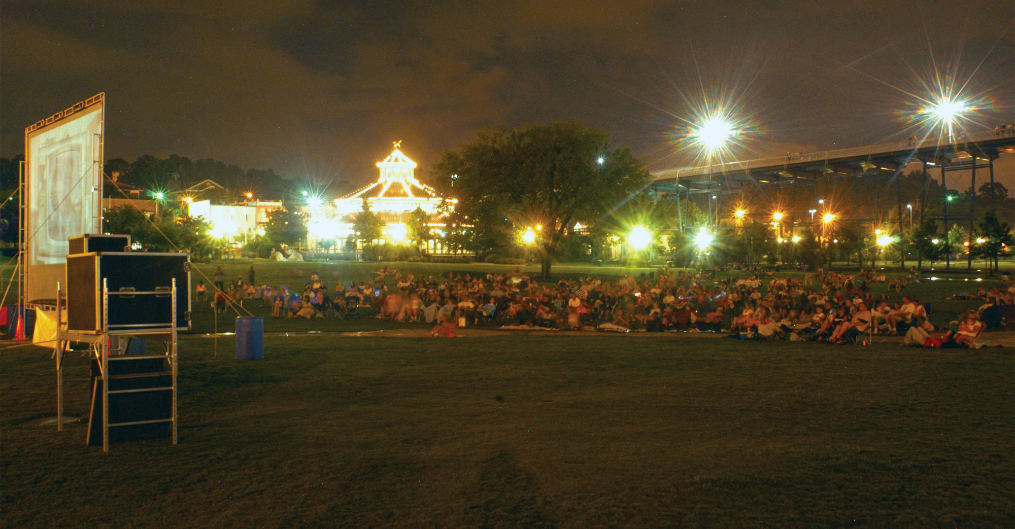 Staff Photo by Steve Davis.  Crowds gather to watch a free showing of Willy Wonka and the Chocolate Factory on Saturday night in Coolidge Park as part of an event sponsored by First Things First.