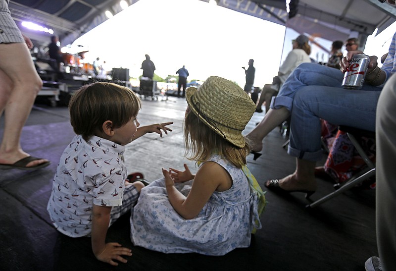 Phoebe Hunt and Elliot Boye, grandchildren of Radiators band member Dave Malone, sit backstage as the venerable Southern rock band performs at the New Orleans Jazz and Heritage Festival in New Orleans, Sunday, May 3, 2015. (AP Photo/Gerald Herbert)