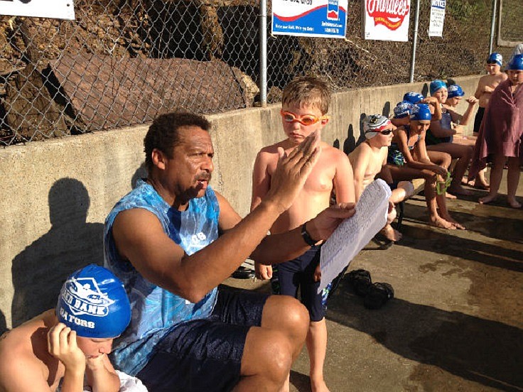 Red Bank Gators coach Ken Buchanan, center, gives some advice to Luke Meyners, right, at a swim meet. Buchanan has been coaching the Gators for 30 years, and the Red Bank Pool was recently renamed in honor of his service.
