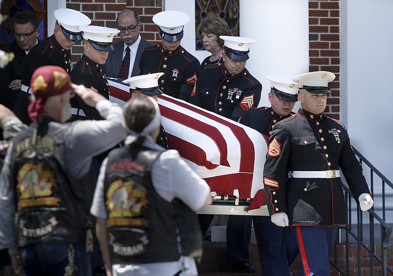 Mourners salute as United States Marines carry the casket of U.S. Marine Corps Staff Sgt. David Wyatt out of Hixson United Methodist Church after his funeral service Friday, July 24, 2015. He was one of five service members killed by an attack on the Naval and Marine Service Center by Mohammad Abdulazeez, who is said 11 months after the attack to have been "radicalized" a year earlier.
