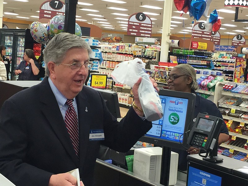 Jim WInsett, president of the Better Business Bureau, buys the first bottle of wine today at the Food City grocery store in St. Elmo.