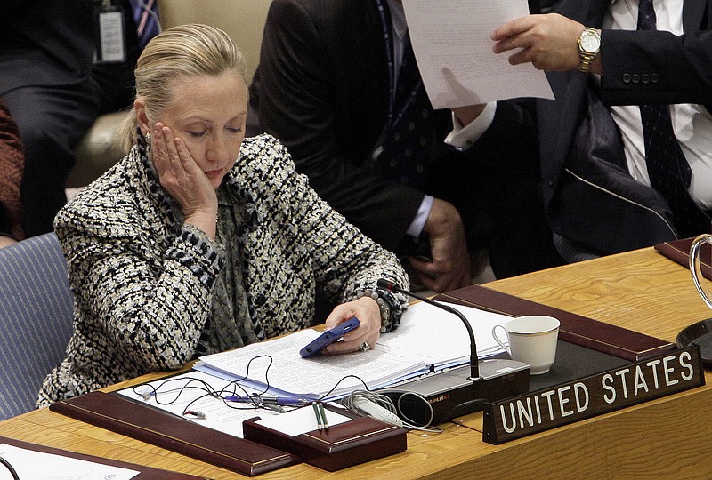 
              FILE - In this March 12, 2012 file photo, then-Secretary of State Hillary Rodham Clinton checks her mobile phone after her address to the Security Council at United Nations headquarters. An impromptu meeting between Bill Clinton and the nation's top cop could further undermine Hillary Clinton’s efforts to convince voters to place their trust in her, highlighting perhaps her biggest vulnerability. (AP Photo/Richard Drew, File)
            