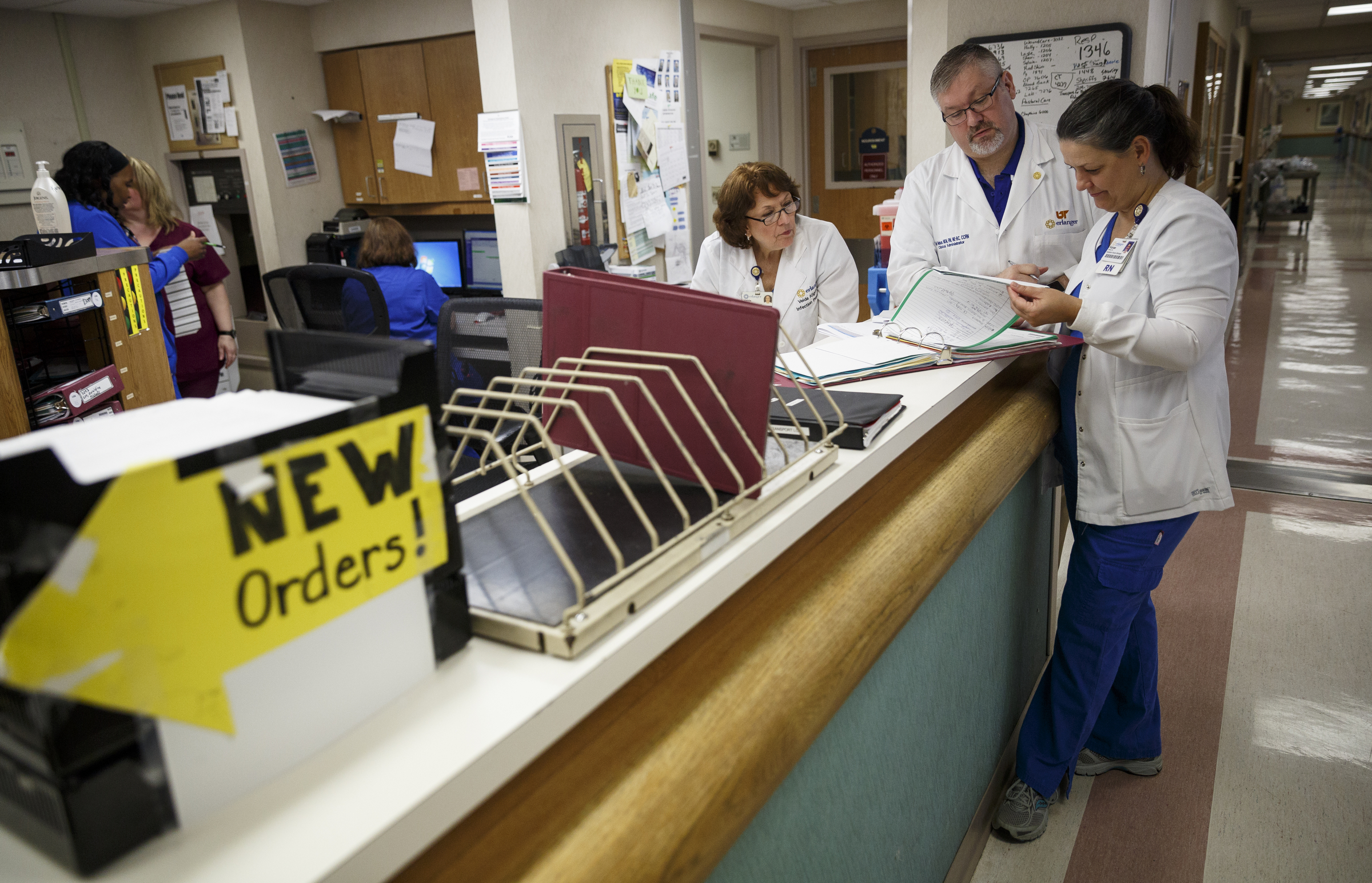 Infection prevention nurses Kanae Gilliland, right, and Velda Kilgore, left, and clinical administrator Ted Nelson review patient charts to find patients who have received catheters at Erlanger Hospital on Friday, June 24, 2016, in Chattanooga, Tenn. The trio are a team responsible for ensuring that catheters are properly placed to reduce the chance of infection.