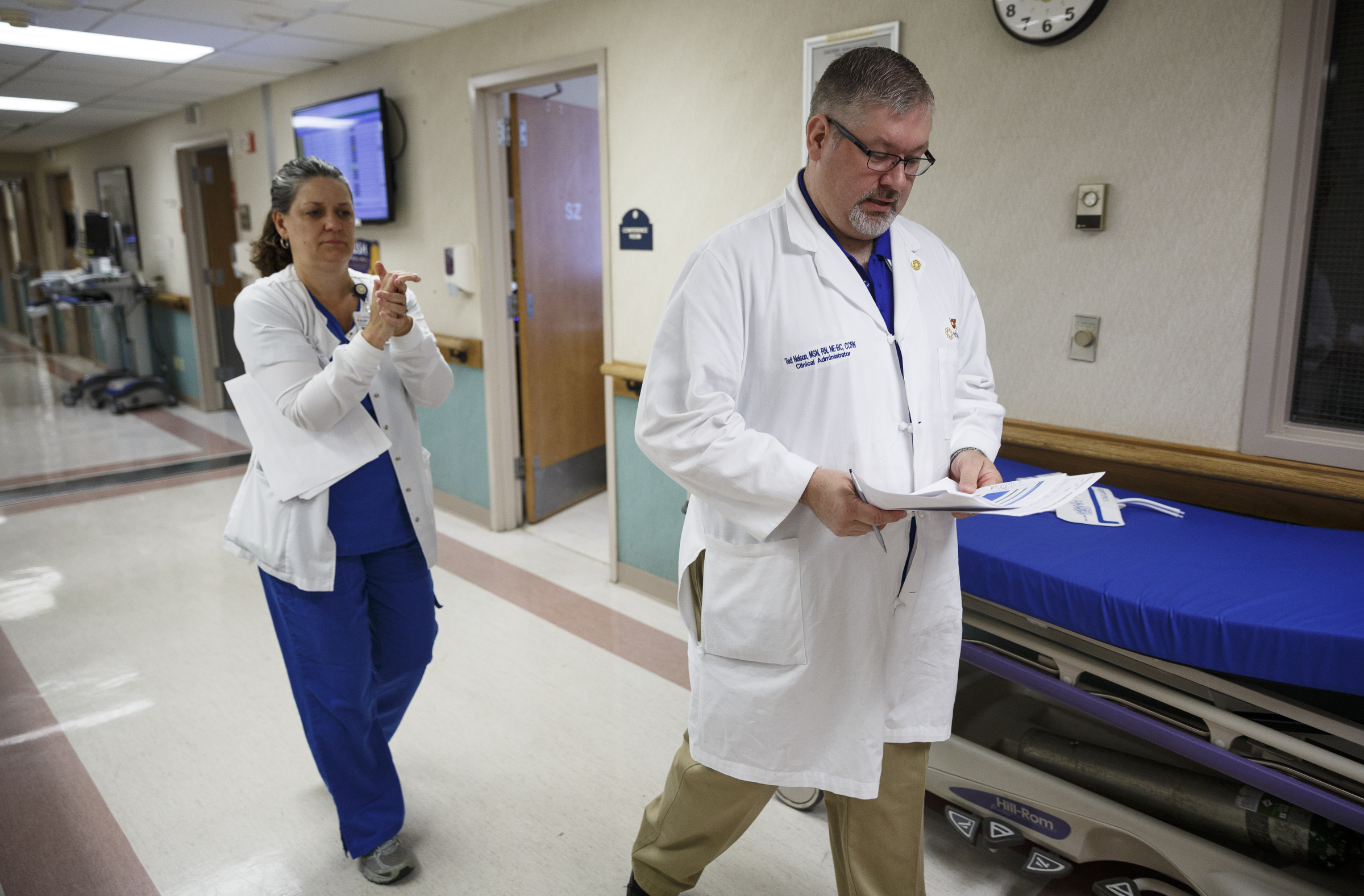 Clinical administrator Ted Nelson, right, heads to the next stop as infection prevention nurse Kanae Gilliland uses antibacterial sanitizer to clean her hands at Erlanger Hospital on Friday, June 24, 2016, in Chattanooga, Tenn. The two are part of a team responsible for ensuring that catheters are properly placed to reduce the chance of infection.