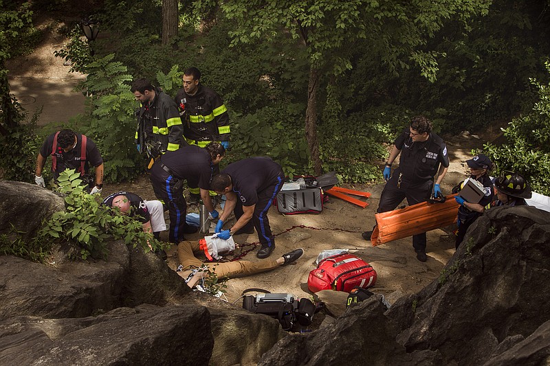 
              A man, center bottom, bleeds from his injured leg as he gets helped from paramedics, firemen, and police in Central Park in New York, Sunday, July 3, 2016. Police and emergency responders took the man on a stretcher from New York’s Central Park after people near the area reported hearing some kind of explosion. Fire officials say it happened shortly before 11 a.m., inside the park at 68th Street and Fifth Avenue. Authorities say the man suffered serious injuries and was taken to the hospital. (AP Photo/Andres Kudacki)
            