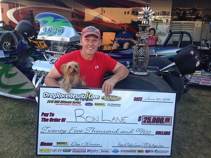 Ron Lane, owner of Ron's Classic Cars in Soddy-Daisy, holds a promotional version of the $25,000 check he won Thursday night at Huntsville (Ala.) Dragway.