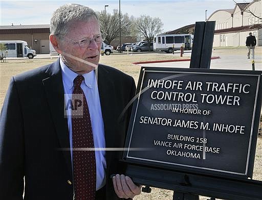 FILE - In this March 4, 2016 file photo, U.S. Senator James Inhofe stands next to a plaque bearing his name after a dedication ceremony for the new air traffic control town at Vance Air Force Base in Enid, Oklahoma. Severe weather forced Inhofe to land an airplane at a small airport in Oklahoma, his spokeswoman said Sunday night, July 3, 2016. Donelle Harder, a spokeswoman for the Oklahoma Republican, said Inhofe was out flying Sunday evening when the weather forced him to land in Ketchum, about 70 miles northeast of Tulsa. (Billy Hefton/The Enid News & Eagle via AP, File)