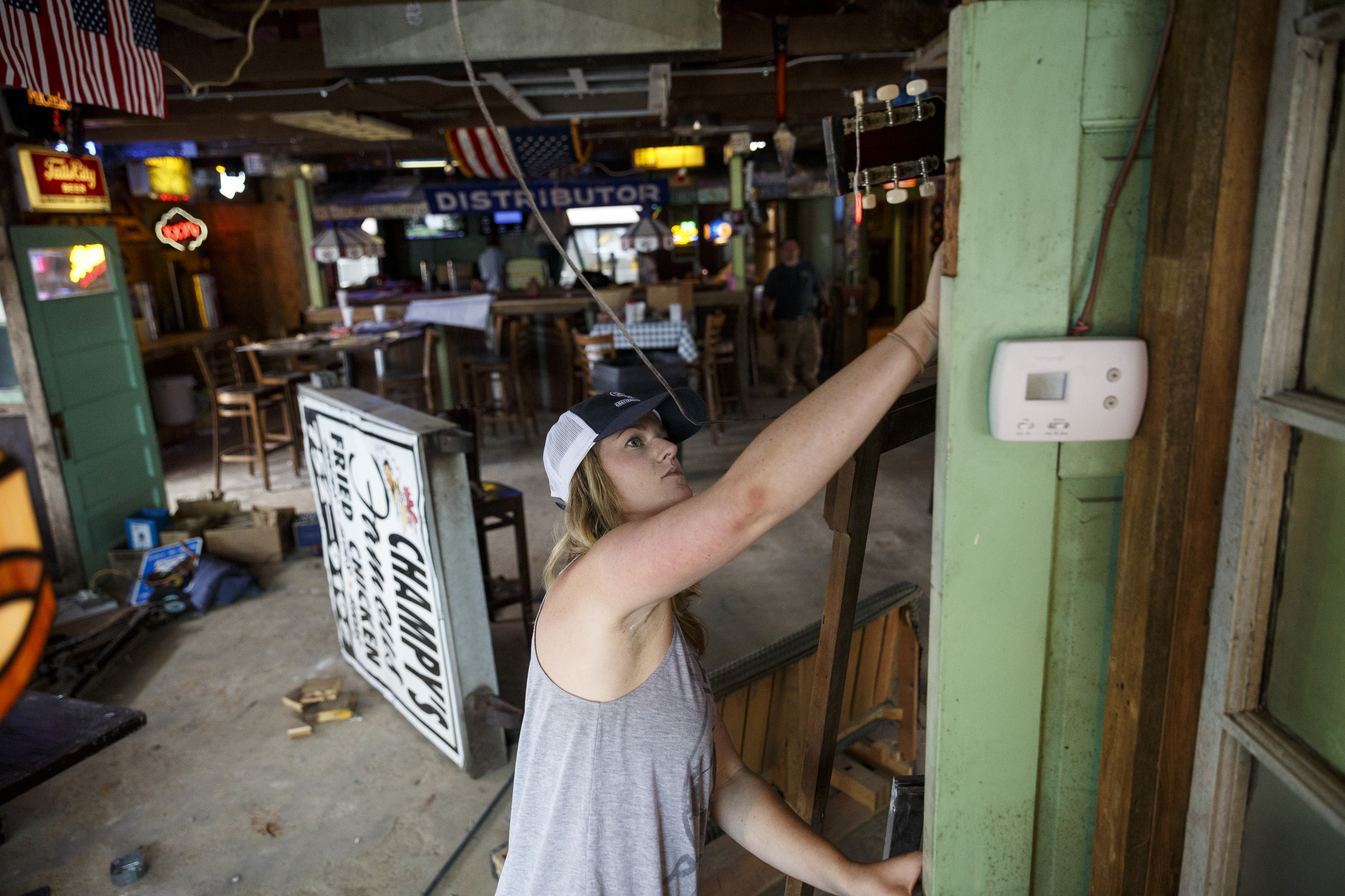General manager Laine Carrigan cleans a door being used for decoration at the new Lee Highway location of Champy's Fried Chicken which is under construction Tuesday, June 28, 2016, in Chattanooga, Tenn.