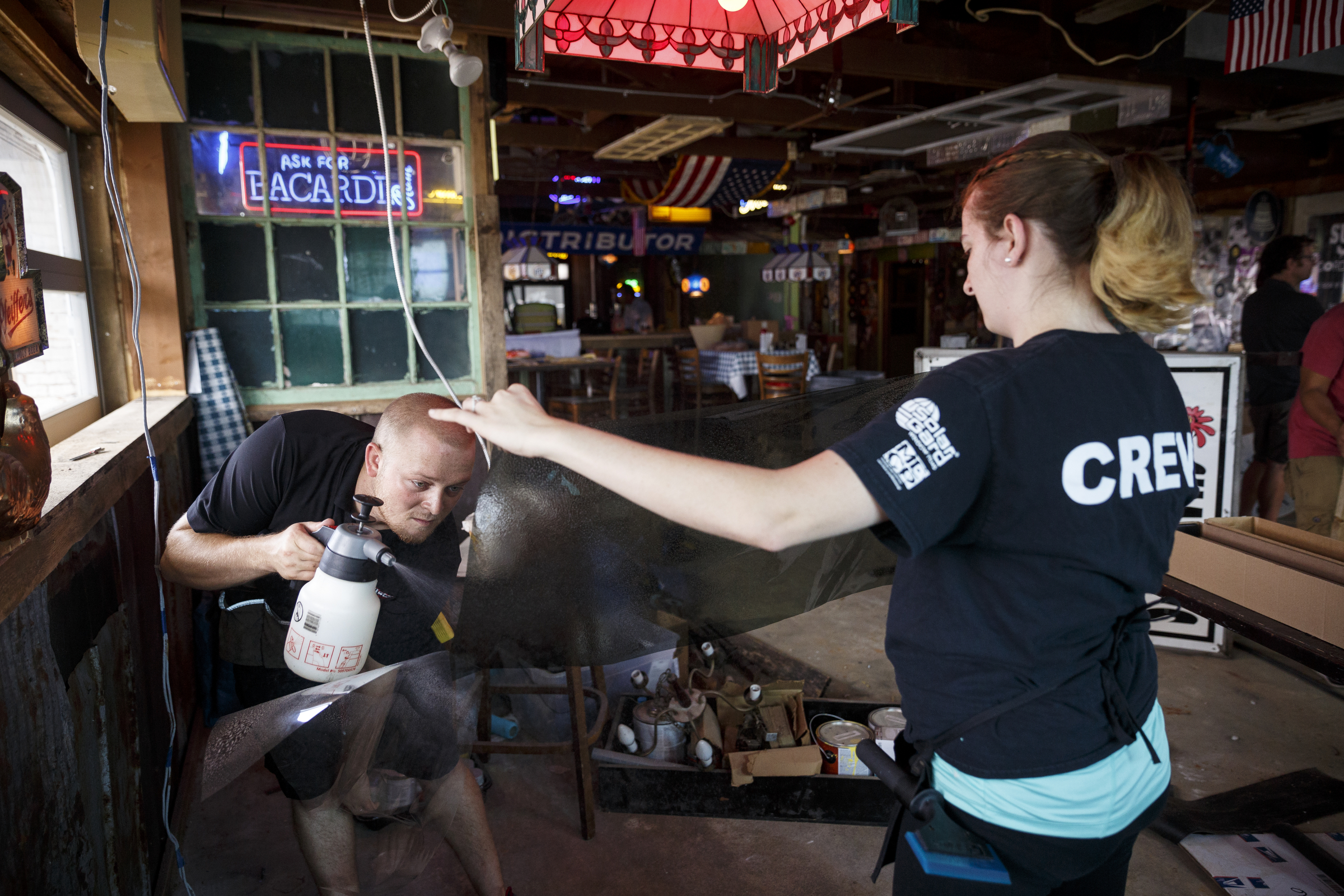 Kyle Henshaw, left, and Emily Burnette apply tinting to windows at the new Lee Highway location of Champy's Fried Chicken which is under construction Tuesday, June 28, 2016, in Chattanooga, Tenn.