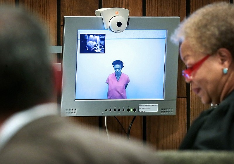 
              Shanynthia Gardner remains silent via video as Judge Loyce Lambert Ryan, right, asks a series of questions during a hearing in court Tuesday, July 5, 2016, in Memphis. The 29-year-old is charged in the fatal stabbings of her four children. (Jim Weber/The Commercial Appeal via AP)
            