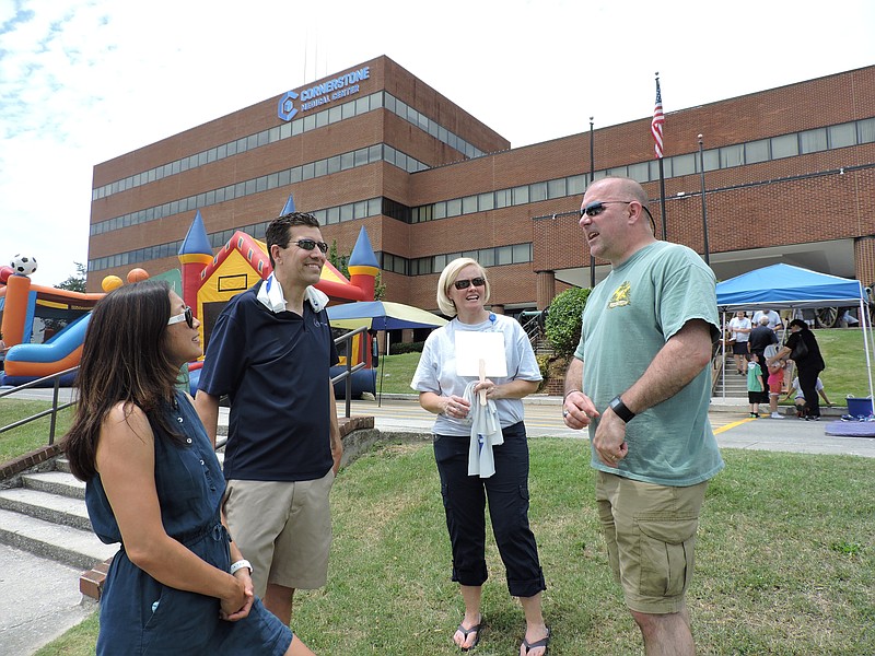 Cornerstone Medical Center staff and family members talk at Family Fun Day. From left are Jennifer Robinson, Apollo MD Divisional President Dr. Boykin Robinson, Cornerstone Chief Nursing Officer Melissa Smeltzer and Chattanooga Police Department's Lt. Mark Smeltzer.
