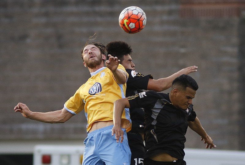 The Chattanooga Football Club's Matt Aldred, left, goes up to head the ball against Quinto Elemento's Carlos Naranjo, center, and Bryan Perez during a Hank Steinbrecher Cup match at Finley Stadium on May 27.