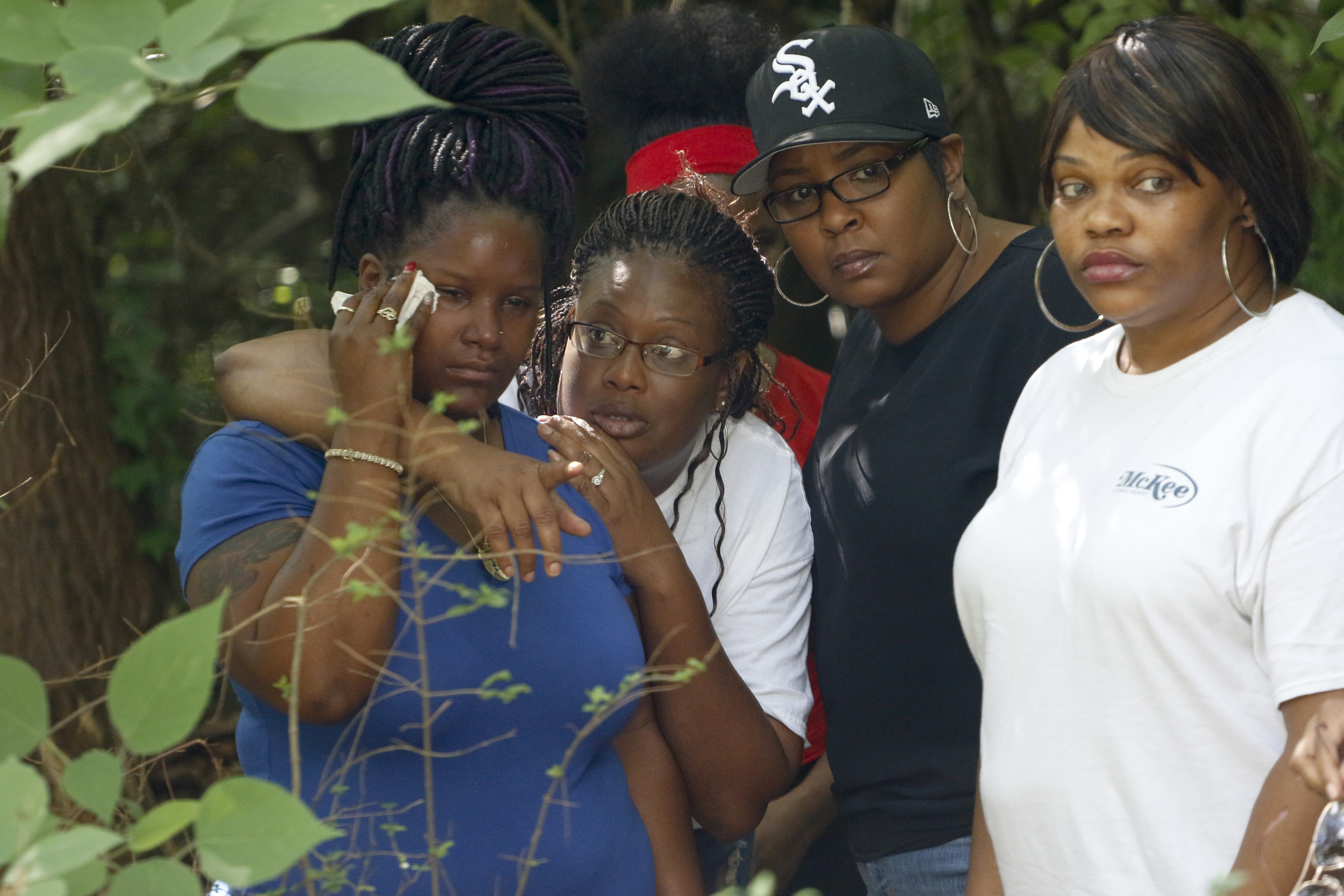 Staff Photo by Dan Henry / The Chattanooga Times Free Press- 7/7/16. Rasheda Trimble, left, is consoled by family members as she visits the site for the first time where her late husband, Justin LaVon Trimble, lost control of his motorcycle and fatally struck a tree upon exiting the Wilcox Tunnel a month ago.