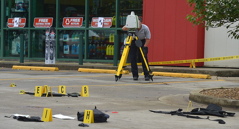 A TBI technician uses a laser mapper in the O'Reilly Auto Parts parking lot to document the crime scene connected to the shooting on Volunteer Parkway early Thursday morning, July 7, 2016. A newspaper carrier was killed and four other people were wounded when a man opened fire on cars traveling along a parkway in East Tennessee early Thursday morning. (Andre Teague/Bristol Herald Courier via AP)
