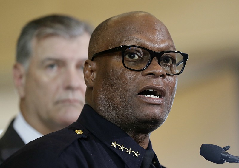 Dallas police chief David Brown, front, and Dallas mayor Mike Rawlings, rear, talk with the media during a news conference, Friday, July 8, 2016, in Dallas.  Snipers opened fire on police officers in the heart of Dallas Thursday night, during protests over two recent fatal police shootings of black men. (AP Photo/Eric Gay)