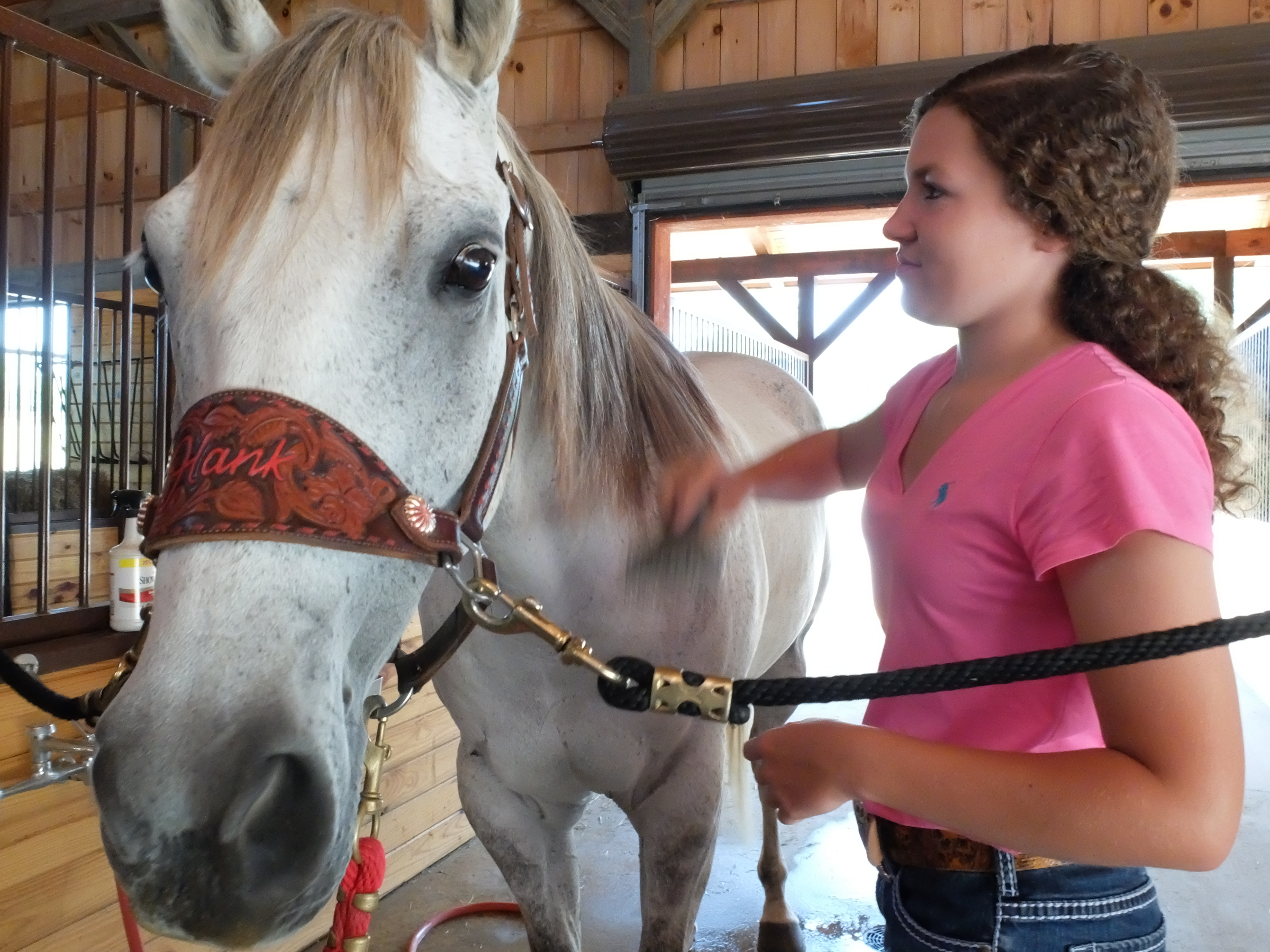 Holli Covey works on the mane of her horse, Hank, before barrel racing work at her father's farm in Ringgold.