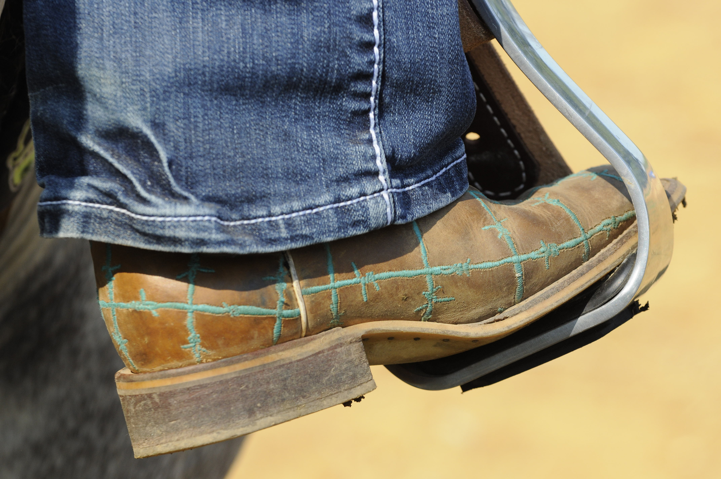 Holli Covey keeps her unique barrel racing boots in the stirrups as she works her horse, Hank, twice daily.