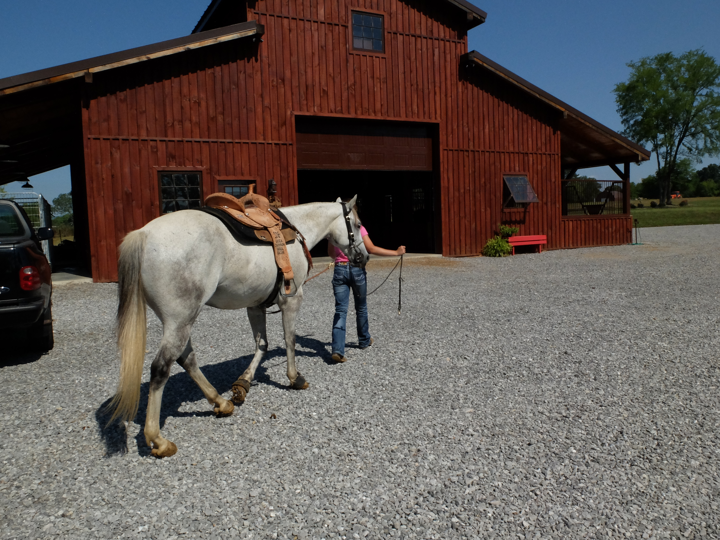 Holli Covey walks her horse, Hank, back to the barn after a session of barrel racing.