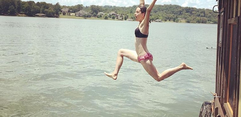 Lauren Benzy leaps from a shantyboat into the Tennessee River.