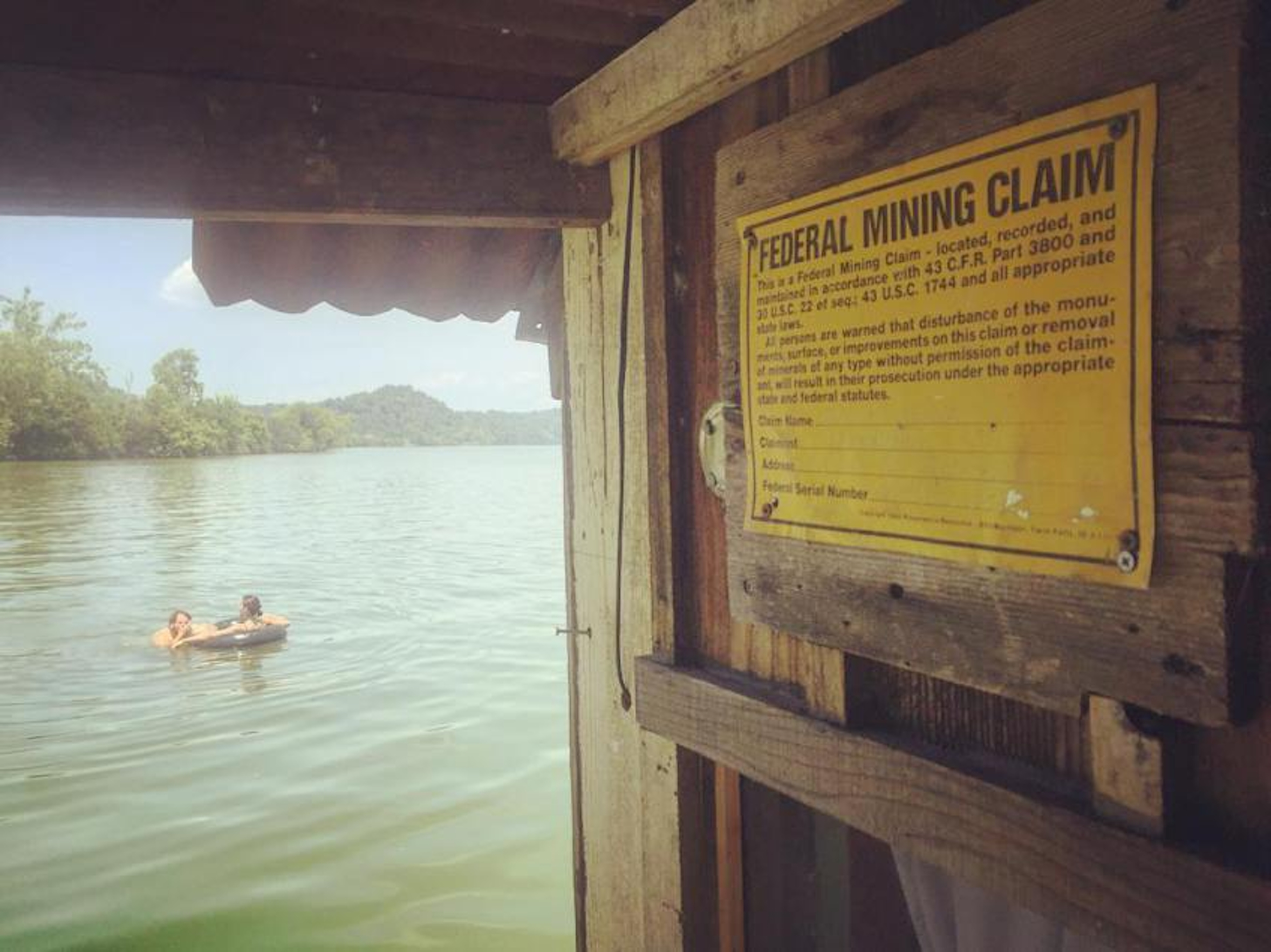 Filmmaker Wes Modes and Lauren Benzy swim off a shantyboat in the Tennessee River.