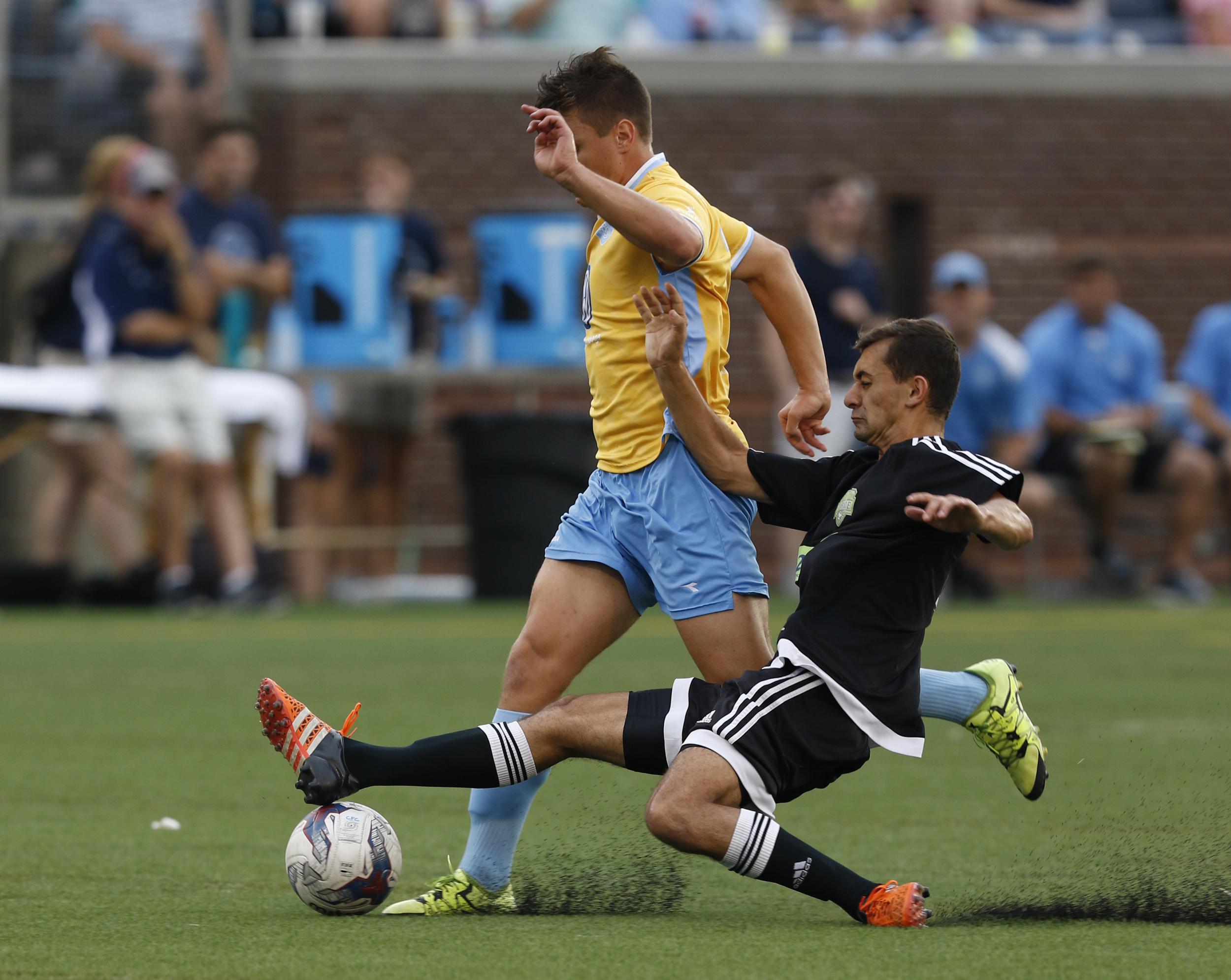 Staff Photo by Dan Henry / The Chattanooga Times Free Press- 7/8/16. Chattanooga Football Club's Will Roberts (32) maintains possession of the ball as Knoxville's Ethan Snow (6) attempts a slide tackle during the first half of play at Finley Stadium on Friday, July 8, 2016.